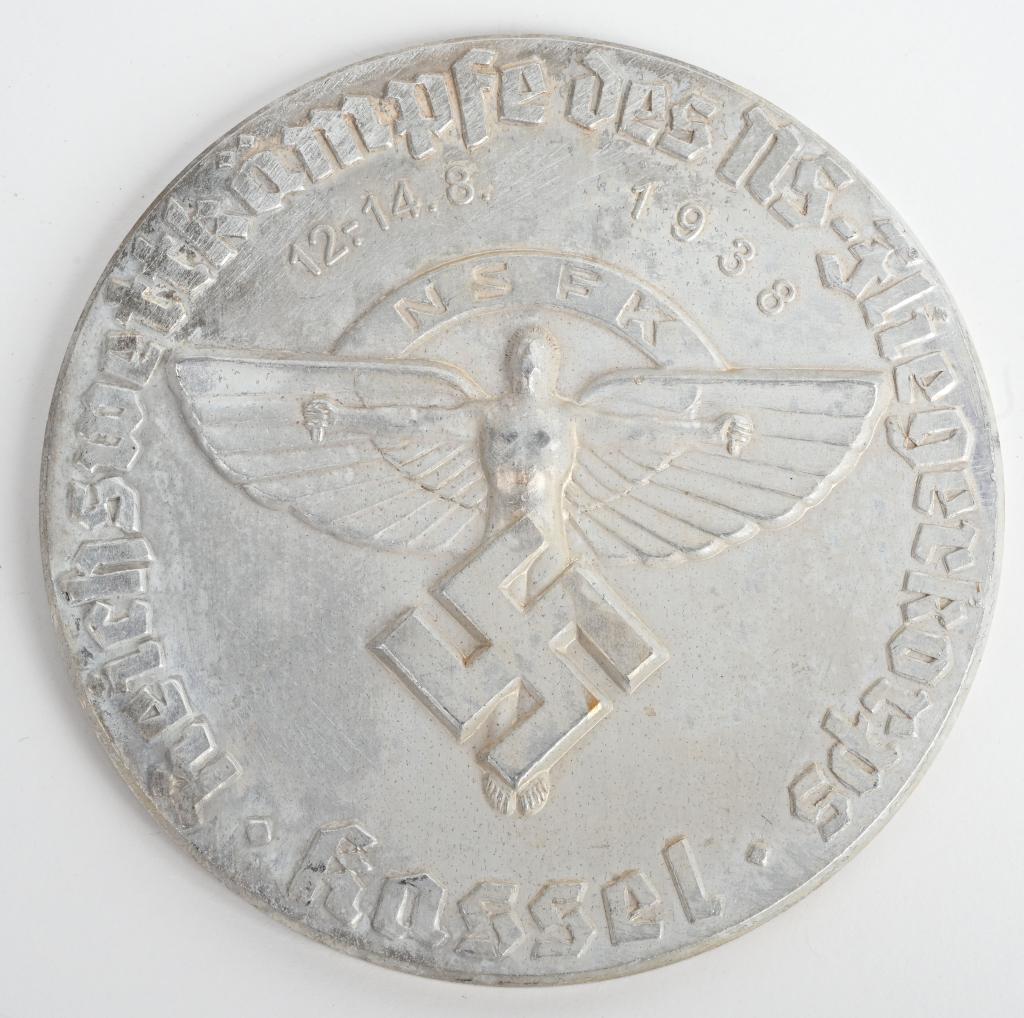 WWII NSFK KASSEL CHAMPIONSHIP PLAQUE 1938 WW2: (Nationalsozialistisches Fliegerkorps Reichswettkämpfe des NS-Fliegerkorps Kassel Abzeichen). Constructed of silvered aluminum; the obverse illustrating a mobile swastika superimposed on a winged man