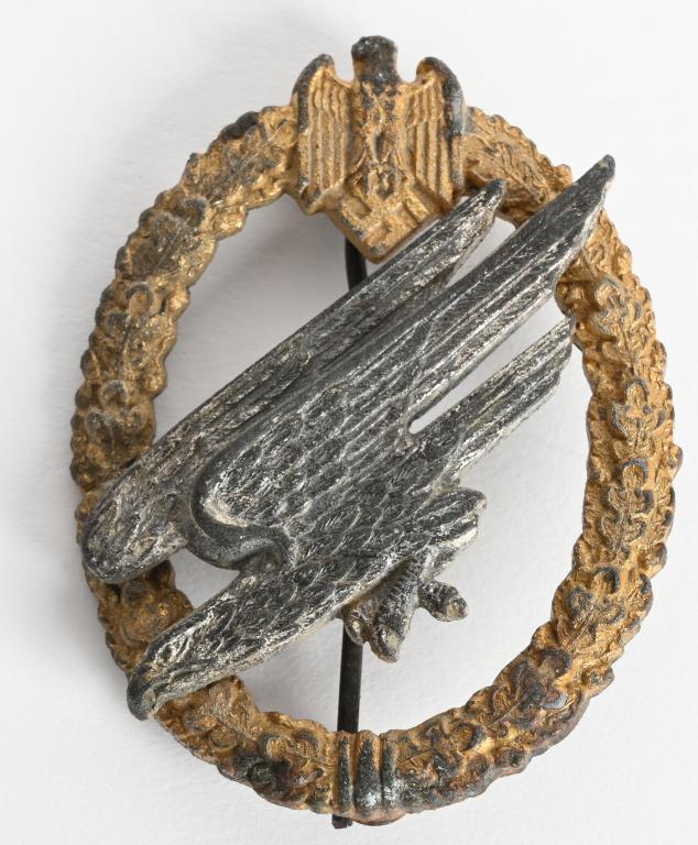 WWII NAZI GERMAN ARMY PARATROOPER'S BADGE WW2: Two piece, die struck alloy construction badge with gilted and silver washed finishes. The badge is in the form of a vertically oval, oak-leaf wreath with a small Wehrmacht style eagle with down swept