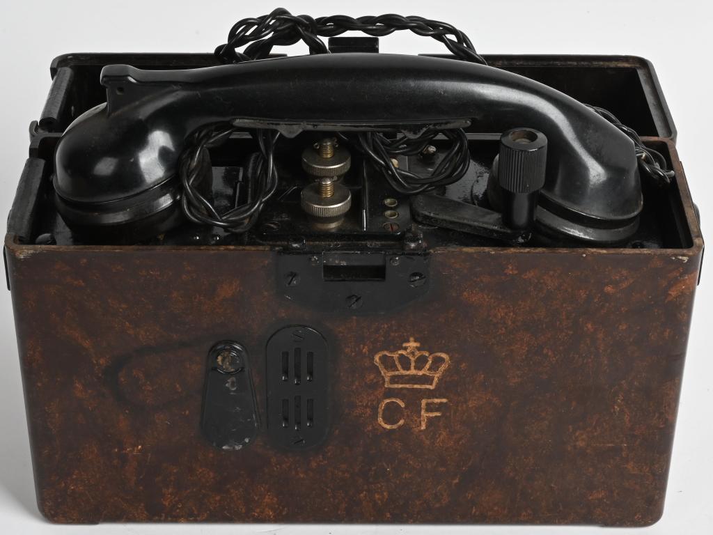 WWII NAZI GERMAN ARMY F33 FIELD TELEPHONE 1940 Dt: The roughly, 22cm tall, 28cm wide, 9cm thick, molded mottled brown Bakelite construction telephone housing case has a fold back top lid with a screwed on, magnetic sheet metal, horizontal bar hinge to