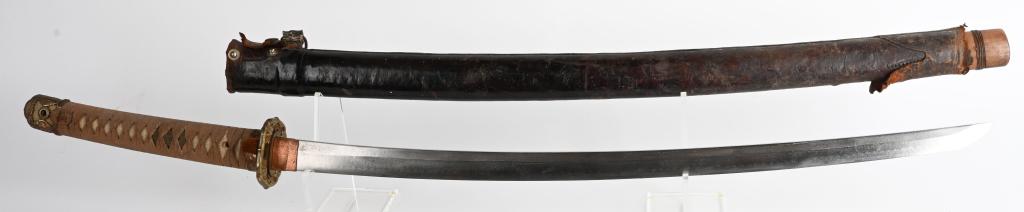 JAPANESE WWII SHI GUNTO KATANA SWORD: The katana has a 25 1/2" cutting edge. Blade has wear and light pitting with visible active hamon. Unsigned tang. Has Shin Gunto mounts and saya has leather combat cover. Includes a cloth katana bukur