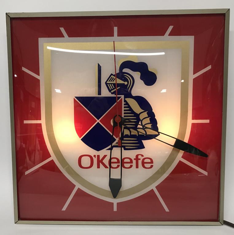 O'KEEFE ALE PAM LIGHT-UP CLOCK: Very nice O'Keefe Ale Pam Clock. Face has great colors and Knight oin armor logo. Metal back in in fine shape. Lighted up and worked when tested. A nice Beer Advertising Clock. 15" Excellent