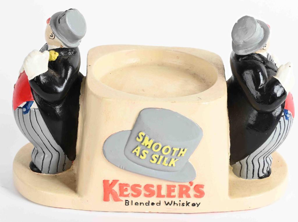 KESSLER'S WHISKEY BOTTLE DISPLAY: Kessler's Whiskey Bottle Display. Has Hi and Ha figures. Made of composition. 9" Excellent