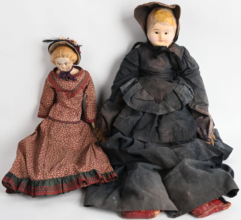 2- EARLY DOLLS, WOOD and WAX HEADS: Lot includes a 25" doll with a paper mache wax head and glass eyes. Has cloth and leather body. The other doll has a painted carved wood head with cloth body. Both have condition issues, but display w