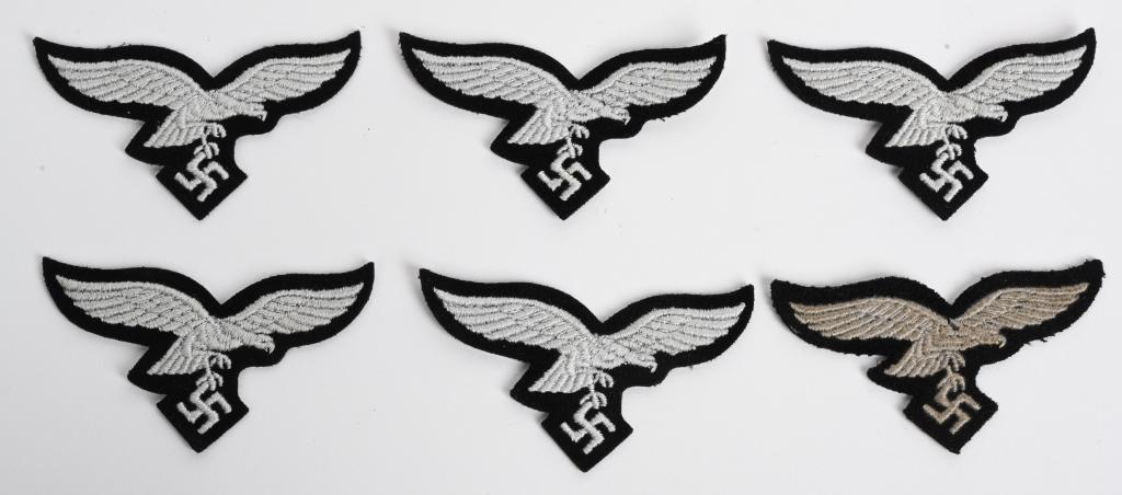 WWII NAZI GERMAN HERMANN GORING PANZER M43 EAGLES: HERMANN GÖRING DIVISION / GROUND CREW EM/NCO'S OVERSEAS / M43 CAP EAGLE LOT OF 6. Six machine embroidered, second pattern, Luftwaffe M43/overseas cap eagles in silvery/gray threads on cut-out black w