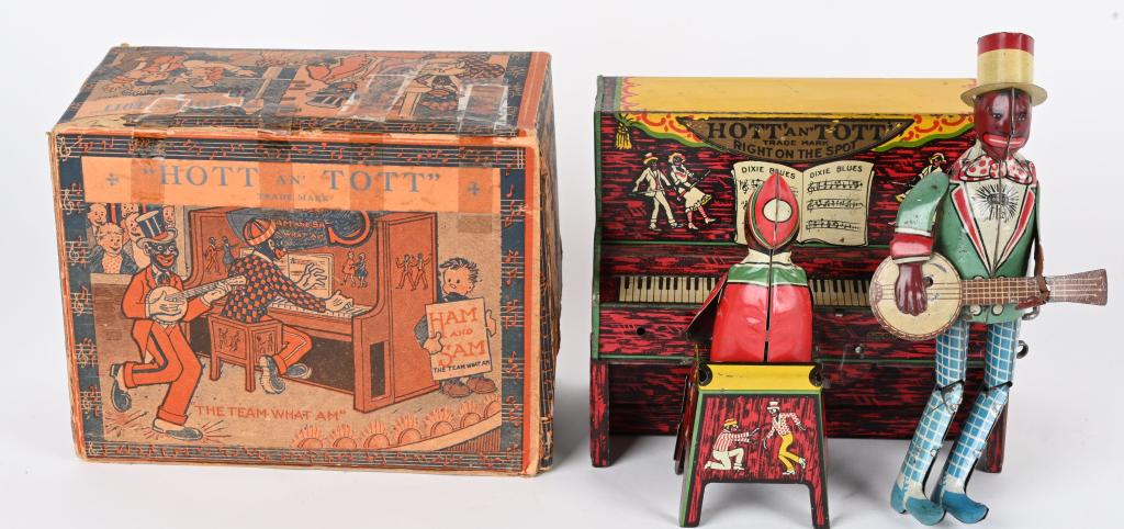 STRAUSS TIN WINDUP HOTT & TOTT BAND w/ BOX: Strauss tin windup Hott and Tott Band. All original and complete. Minstrel Team playing at the piano. Very nice colors. Windup works. Comes with original box with some taped flaps. 6" Excellent