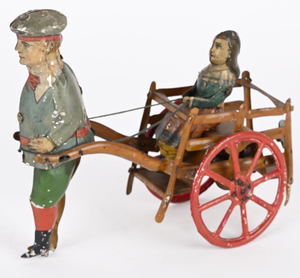 GERMAN TIN WINDUP BOY PULLING GIRL IN CART (1 of 5)