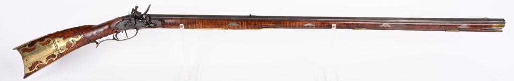 ORNATE EARLY P SHRAK .45 CAL FLINTLOCK LONG RIFLE: Very ornate Flintlock Long rifle with 41" octagon .45 cal, rifled barrel measuring 1" across flats. Full length striped maple stock with pierced and tastefully floral engraved 4 piece brass patch box 