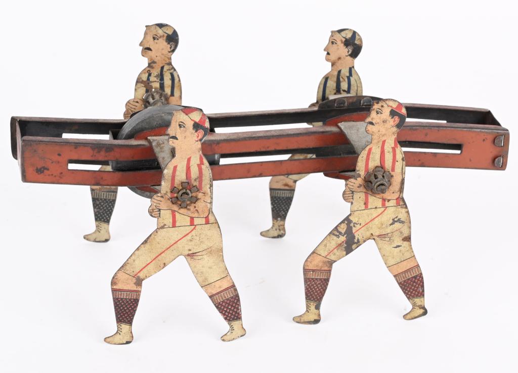 TIN WALKING BALL PLAYERS GYRO TOY: Unusual toy with 4 Ball Players that walk along when lead gyro is spun. Nice colors. 8 1/2" Very Good-Excellent