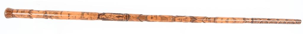 EXQUISITE SPANISH AMERICAN WAR CARVED WALKING CANE: Exquisite wood walking stick with a Spanish American War themed engraving measuring a total of 33 inches long. Cane shows pivotal moments and historical figures during the War such as the attack on Sa