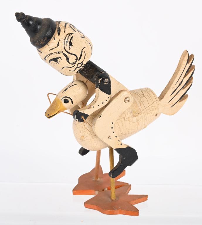 VINTAGE WOODEN WITCH RIDING GOOSE: Very unusual wooden Witch riding a goose. The head of the Witch just sits on a nail so it moves around. Show patina. 9 1/2" Excellent From the James and Helen Berkheimer Collection