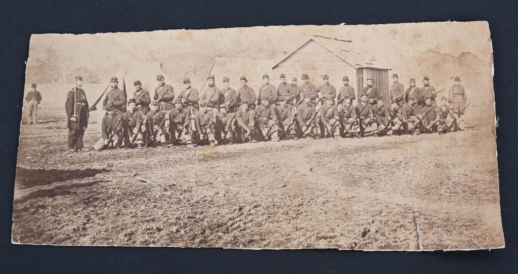 CIVIL WAR ALBUMEN IMAGE OF UNION REGIMENT: Interesting albumen image of a Union regiment posed outside of their camp. The soldiers are in ranks with fixed bayonets. The officer on the left has his sword drawn. In the background are tents and a