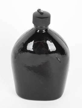 WWII US M42 US BLACK PORCELAIN CANTEEN WW2: A one quart capacity canteen. The black enameled steel canteen is slightly concave to its reverse and retains its flat, black "Bakelite" screw cap, attached between its top and a flange brazed to the 