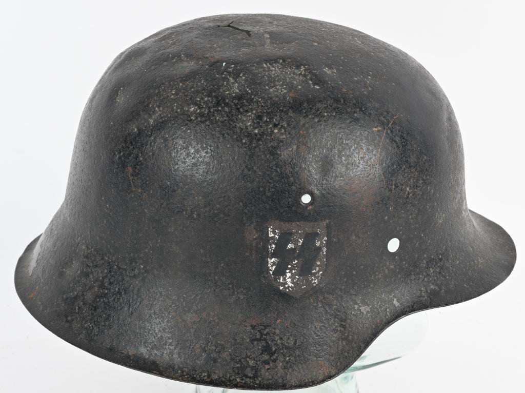WWII NAZI GERMAN WAFFEN SS HELMET DUG W NO LINER: Dug stamped sheet steel construction helmet retains none of its original field-gray paint. The right side of the helmet has a second pattern, "SS" runic decal with black runes on a silver shield shape