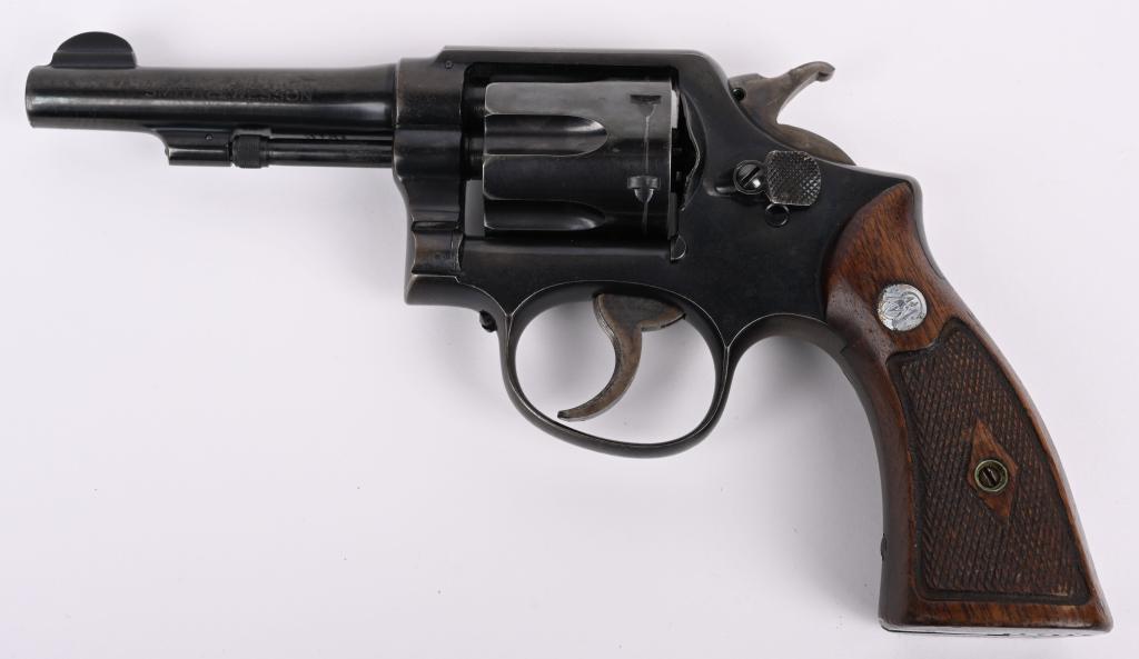 SMITH & WESSON MODEL POST WAR H.E. 38.: SERIAL S817612. BARREL 4". CALIBER .38 SPECIAL Built on square butt K-frame, 5-screw with blue finish, case color hammer & trigger with silver medallion, diamond checkered walnut grips. Condition. Gri