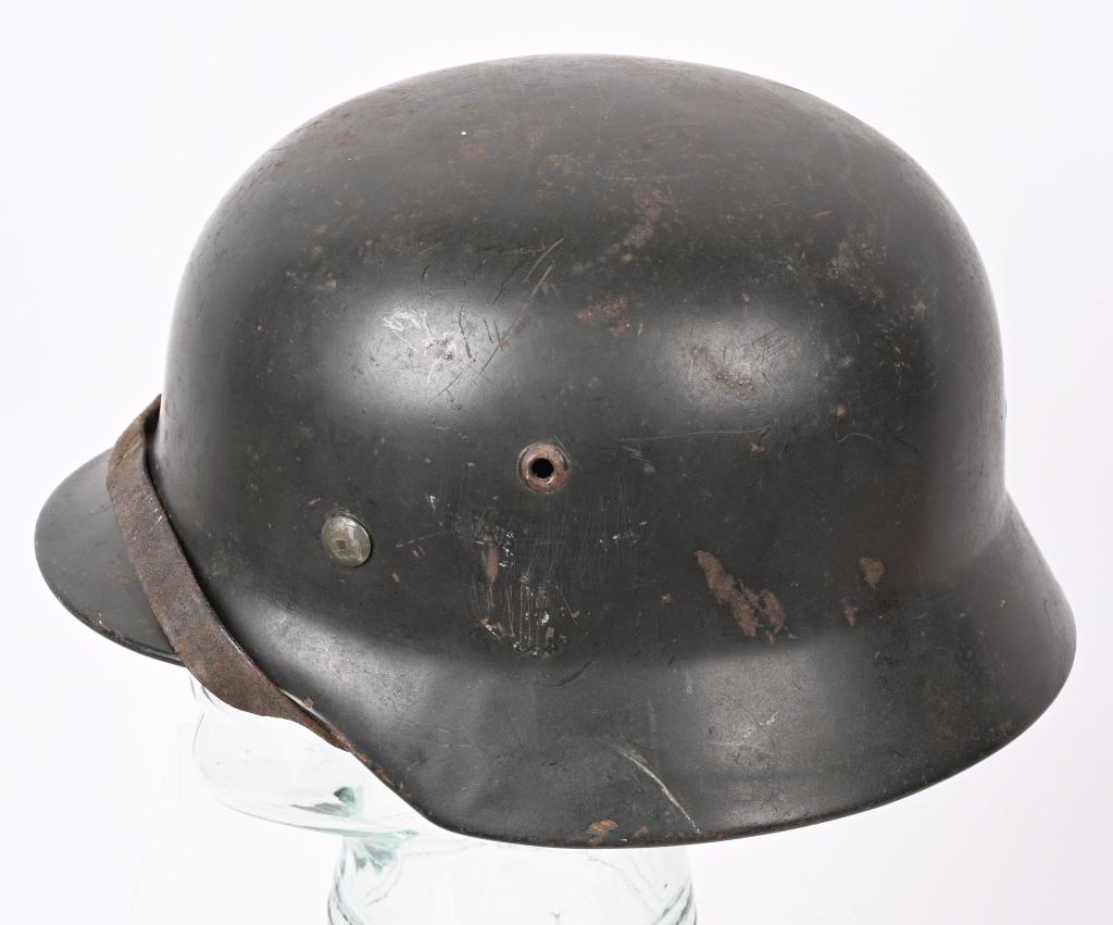 WWII NAZI GERMAN M35 COMBAT HELMET W/ LINER WW2: The stamped, sheet steel construction helmet most of its original, smooth, light parade green paint. All three liner retaining rivets and both inserted ventilation bushings are all intact. The interio