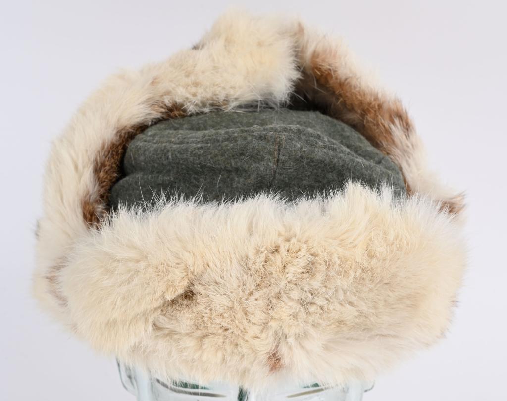 WWII NAZI GERMAN WEHRMACHT WINTER FUR CAP WW2: Field-gray wool construction cap with rabbit fur front, fold down side ear lugs and back panels. Tie-string complete. Quilted rayon liner. Roughly a size 54 and dated 1942. Excellent The severe c