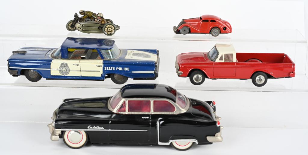 LOT OF TIN TOY CARS & MOTORCYCLE: Includes German windup Motorcycle with Sidecar missing Gun, Schuco windup Car, Japan tin friction State Police Car. Japan tin friction Pickup, and Modern tin friction Cadillac. Largest 10" Excellent