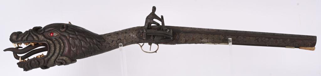 HIGH ART SILVER MOUNTED MIQUELET CARBINE: Carved and addorned for possible Asian marked with detailed dragons head butt with profuse silver inlays on carbine stock. Tapered Octagon barrel with imense silver overlay in a scroll & vine pattern.