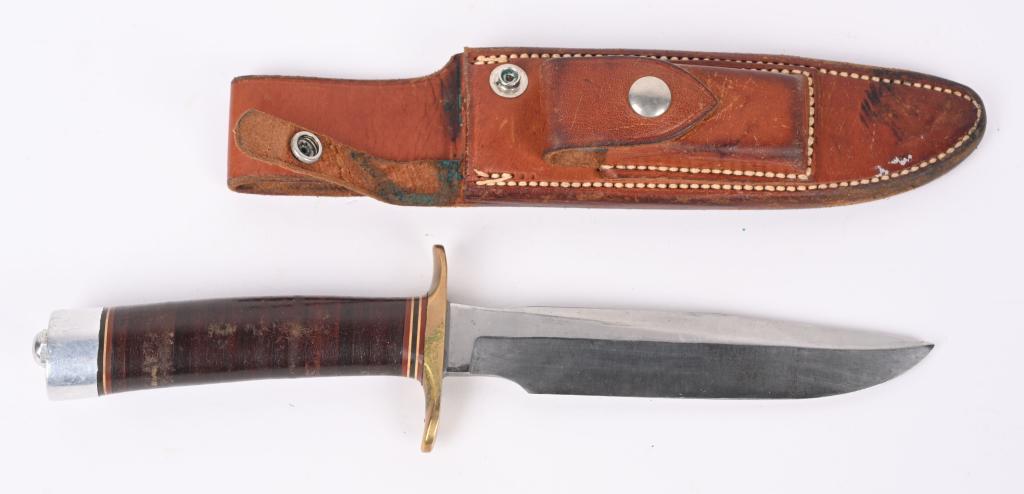 EARLY RANDALL MODEL 1 ALL PURPOSE FIGHTING KNIFE: 6 inch carbon steel blade with brass double guard, sole leather grip with duralumin butt cap. Marked on left side of blade "RANDALL MADE ORLANDO, FLA" Rough back Johnson scabbard with grey sharpening 