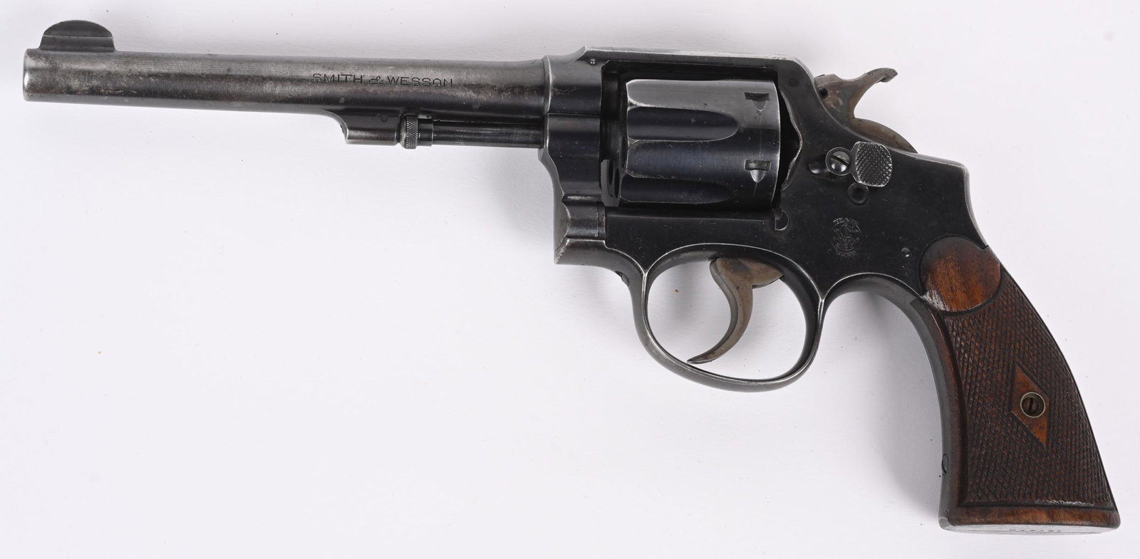 SMITH & WESSON MODEL 32-20 HAND EJECTOR: SERIAL NUMBER 127570 BARREL 6" CALIBER .32-20 WINCHESTER MANUFACTURED 1915-40. Hand Ejector pattern 5 screw K frame. Blue finish with diamond pattern checkered service grips. Fixed sights with tapered