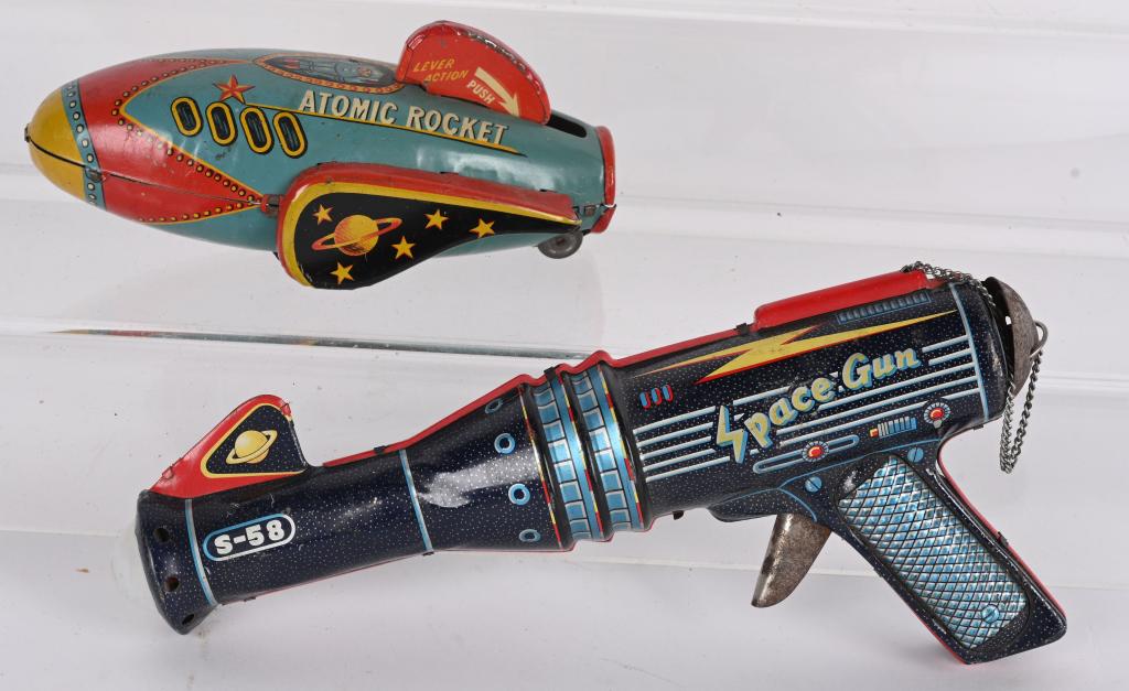 ATOMIC ROCKET & SPACE GUN: Includes Japan tin friction Atomic Rocket and Japan battery operated Space Gun. Both with nice graphics. Largest 10" Excellent