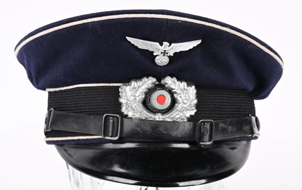 WWII NAZI GERMAN NSKOV VISOR CAP NEAR MINT WW2: A 1936 pattern, deep navy blue wool construction visor cap. Fixed to the forward seam line of the body is a 1938 pattern, stamped aluminum, spread-winged eagle with a wreathed, mobile swastika in its 