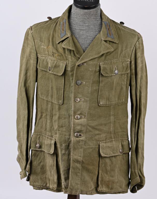WWII NAZI GERMAN TROPICAL FIELD BLOUSE WW2: Light weight, ribbed, khaki/olive, cotton twill construction field blouse features a vertical, six button front closure with small, opened, fold back, peak lapels and a lay down collar. The field blou