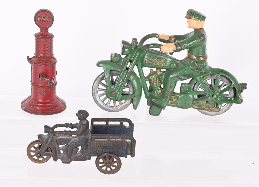 2- CAST IRON TOY MOTORCYCLES & GAS PUMP: Lot includes a Hubley 4 3/4" Crash Car, a Hubley 7" Swivel Head Harley Davidson solo, and a A.C. Williams gas pump. The crash car is missing the rear step. The swivel head has lead replacement wheels,