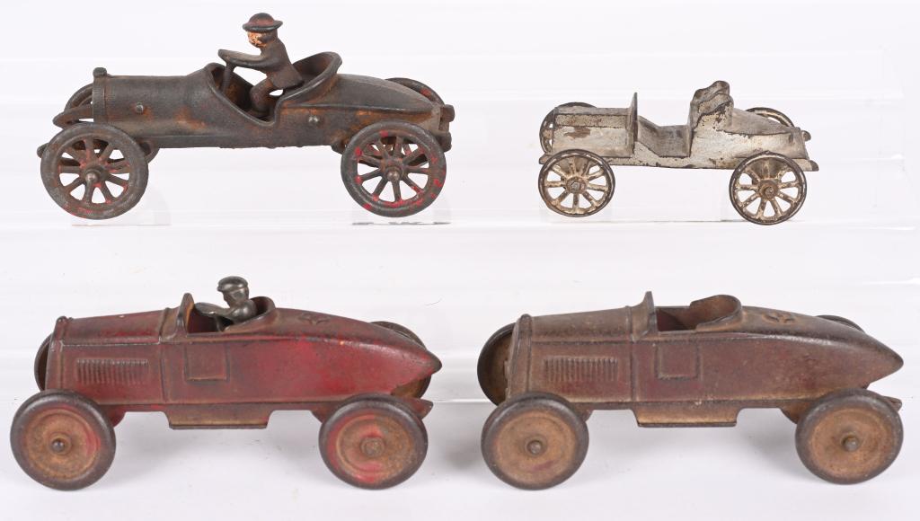 4- CAST IRON TOY RACE CARS: Lot includes 2- 6 1/2" Kenton Boat Tail Racers, a 5" A.C. Williams Racer, and a more contemporary 7" Racer with broken driver. Condition varies. Good-Very Good