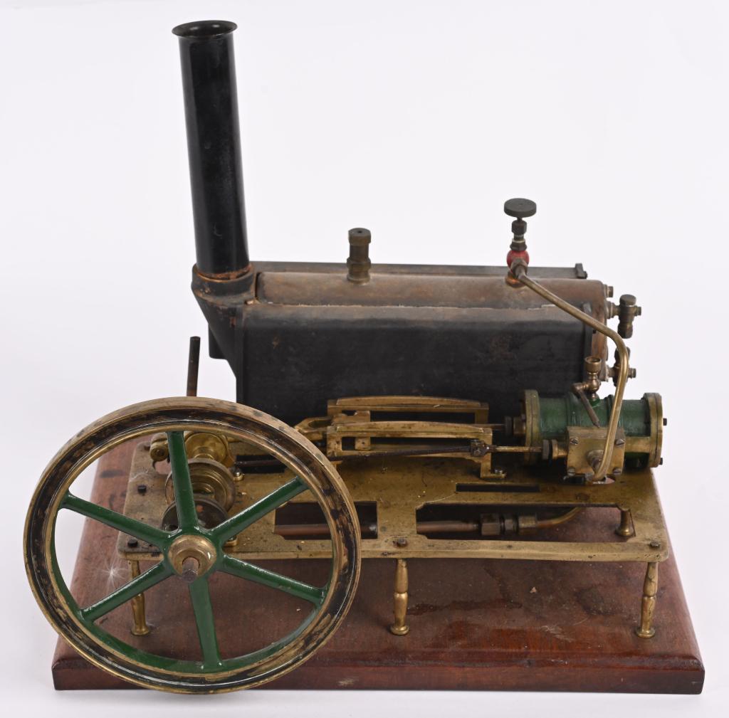 LARGE STUART BRASS STEAM ENGINE: Nice vintage steam engine mounted on a 14" by 11" wood base. Flywheel is 7" diameter. A water line needs re-connected. Very Good