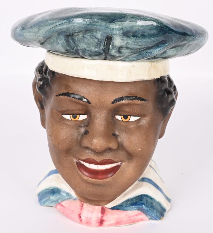 MAJOLICA FIGURAL TOBACCO JAR: Late 19th/early 20th century. Depicting the bust of an African American with a flattened round sailor’s cap. His face with a pleasing expression with nice half smile. SIZE: 6” h. CONDITION