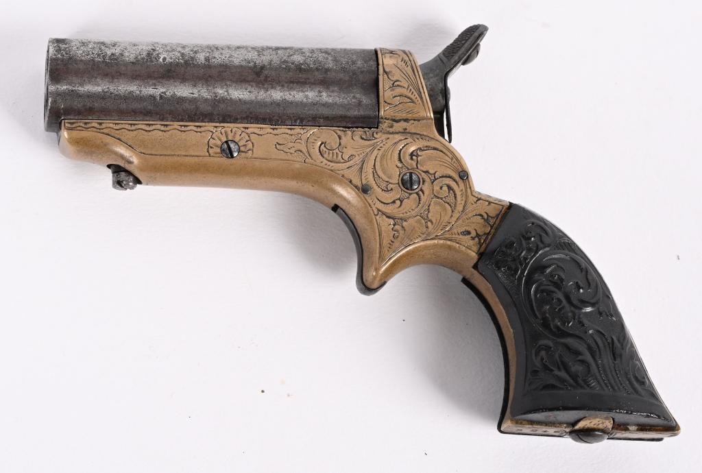 FACOTY ENGRAVED SHARPS 4 BARREL DERRINGER: SERIAL NUMBER: 3248. BARREL: 2-1/2". CALIBER: .22 SHORT. MANUFACTURED: 1860's. "C. SHARPS PATENT 1859" marked on the right side of the barrel. Engraved brass frame. Barrels are blued. Gutta Percha gri