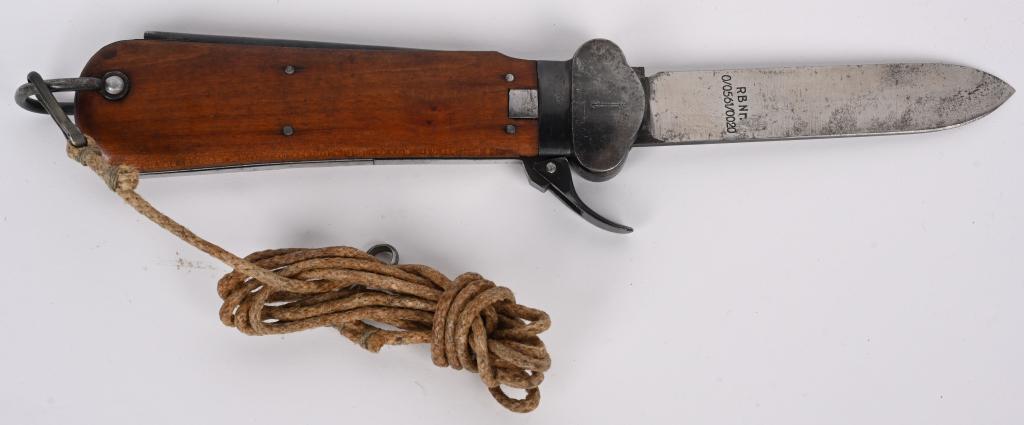 WWII NAZI GERMAN FALLSCHIRMJÄGER GRAVITY KNIFE WW2: A Luftwaffe paratrooper knife using a sliding steel blade inside a metal grip fitted with walnut, the grain running through vertically, grip plates. The blade is a relatively blunt spear-point with a