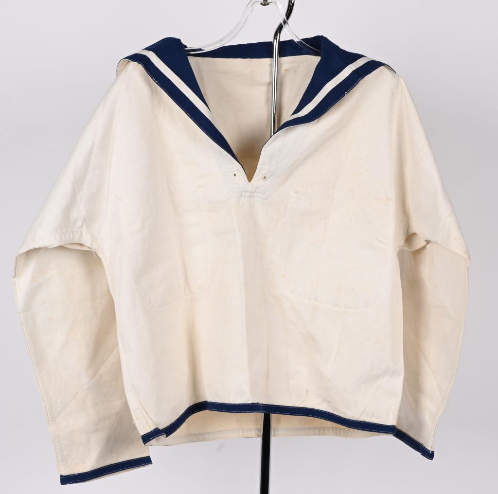WWII JAPANESE ENLISTED WHITE JUMPER WW2: A white cotton "jumper" pullover shirt with a fold back, blue nankeen collar. The rectangular collar hangs over the top back and comes down into the front into a "V" neck slash. To either side of the