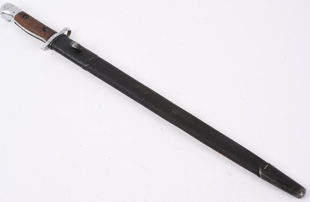 WW1 BRITISH MODEL 1907 BAYONET AND SCABBARD WWI: A 1907 pattern bayonet and Mk l scabbard. The bayonet’s, contoured bird’s head pommel has a stud guide and stud. The contoured wooden grips are fixed with two screws. The contoured metal c