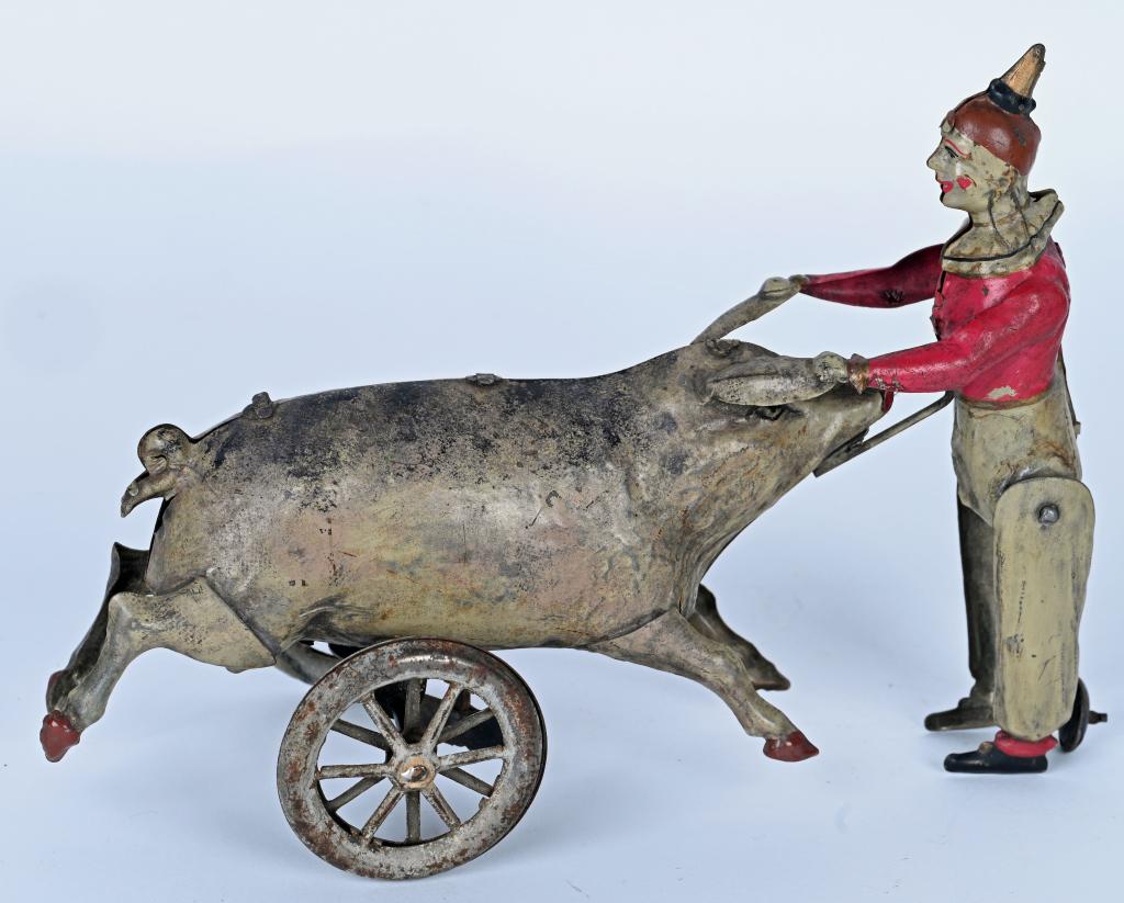 ISSMAYER HAND-PAINTED WINDUP CLOWN PULLING PIG: German Hand-Painted Tin Clown Pulling Pig By Ears. Very whimsical toy. Windup works. Has some restoration. 7 1/2" Excellent
