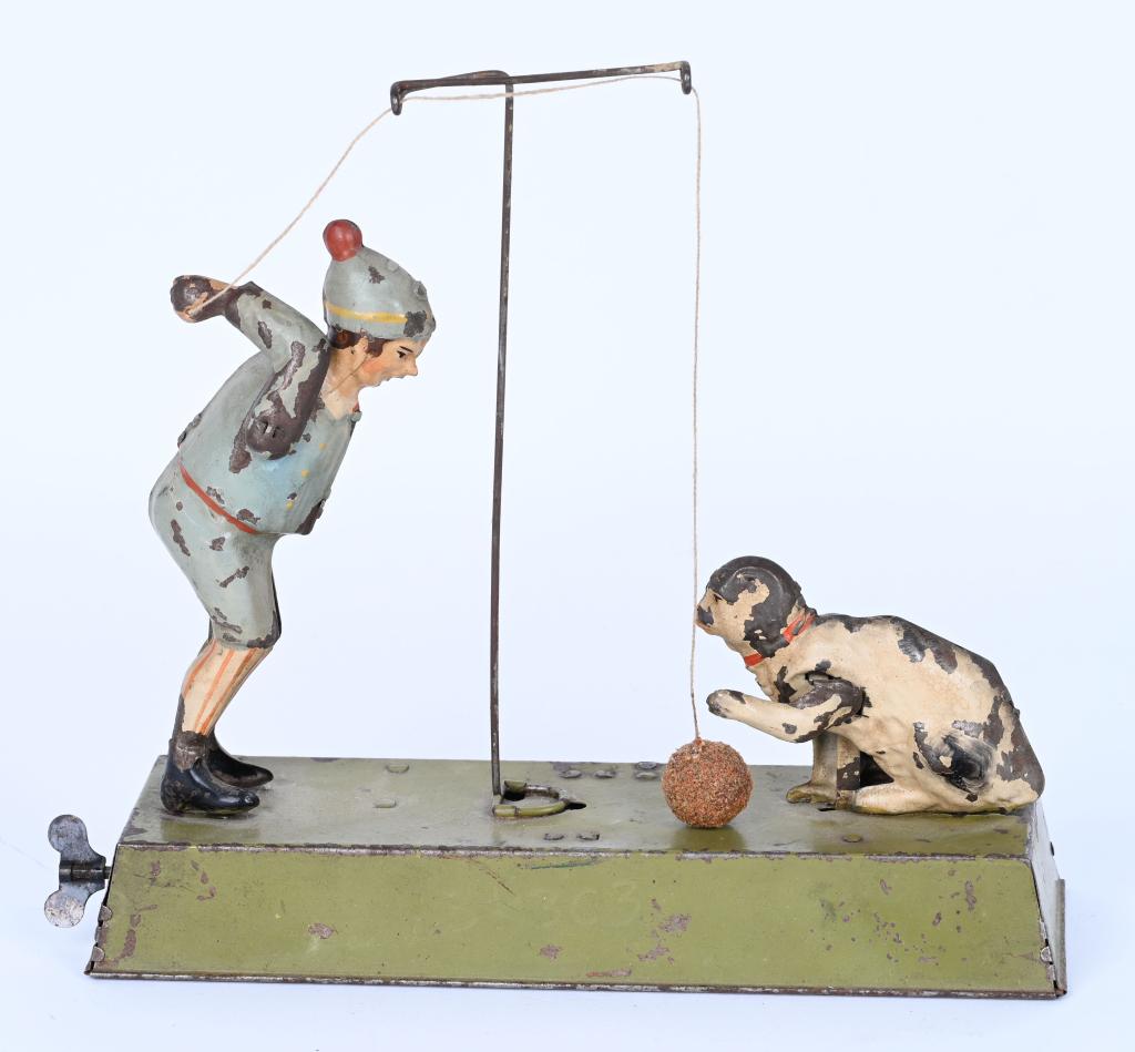 GERMAN HAND-PAINTED WINDUP BOY & CAT PLAYING BALL: Wonderful German Hand-Painted Tin Boy with Cat Playing Ball. All original and works well. Boy moves arm bouncing he ball while Cat bats away at it. 10" Excellent