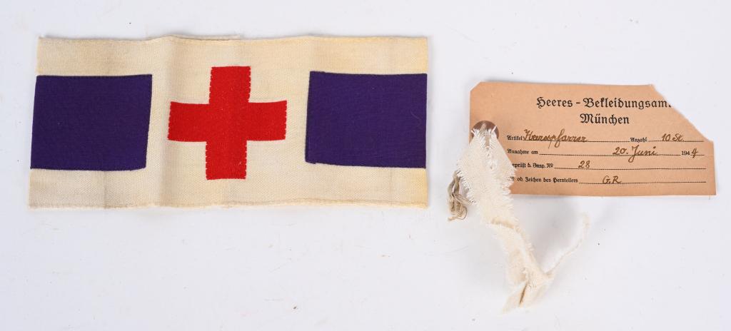WWII NAZI GERMAN CHAPLAIN ARMBAND W TAG WW2: Measures 7 5/8” wide by 3 6/8” tall. The front shows a Red Cross in the center flanked by purple strips on each side. The reverse side is stamped in black ink and reads ‘Rur fur beu 