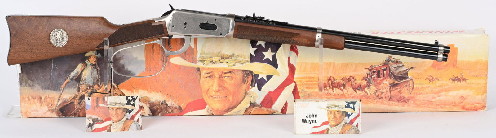 BOXED WINCHESTER JOHN WAYNE COMMEMORATIVE CARBINE: SERIAL JW37134. BARREL 18.5". CALIBER 32-40. MADE 1981. The left side of the barrel is marked “Winchester Model 94 32-40 Win. / Made In New Haven, Conn. U.S.A. Winchester Proof Steel”. The top of 