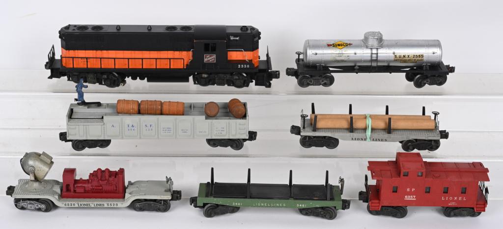 LIONEL 2338 GP7 ENGINE & FREIGHT CARS: Lionel #2338 GP7 Engine with Operating Barrel car, Searchlight Car, Sunoco Tank Car, Flat Car with Logs, Dumping Flat Car, and Caboose. All in played with condition. Very Good-Excellent