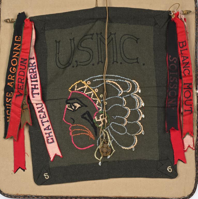 WWI USMC TRENCH ART BLANKET W INDIANHEAD MEDALS: WWI USMC Trench Art, made from the center section of a Marine Corps Blanket. The decorative piece has a large side profile of an Indian Chief in multi-colored yarn. On the headdress of the Chief is a 