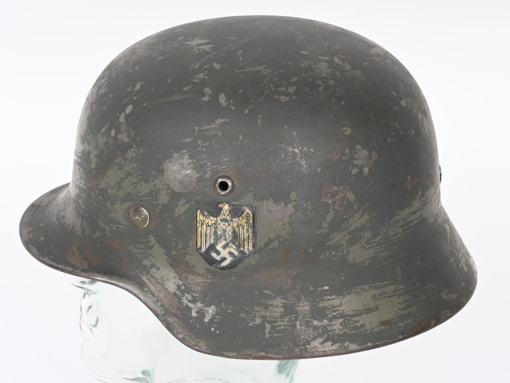 WWII NAZI GERMAN M35 DD WEHRMACHT HELMET W LINER: The stamped, sheet steel construction helmet retains a good portion of its overpaint from the apple green finish and looks like it may have had partially applied rough textured camo paint applied at o