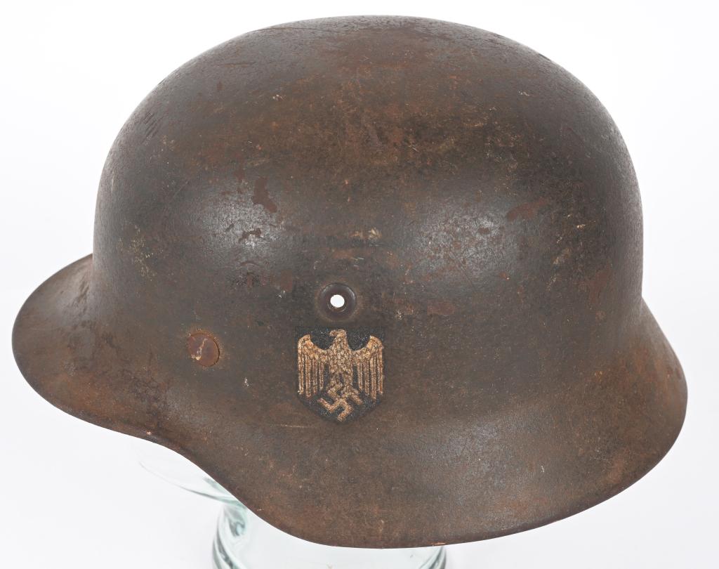 WWII NAZI GERMAN WEHRMACHT M40 SD COMBAT HELMET: The stamped, sheet steel construction helmet a portion of its original feldgrau paint. National Eagle retains about 70%. All three liner retaining rivets and both inserted ventilation bushings are all