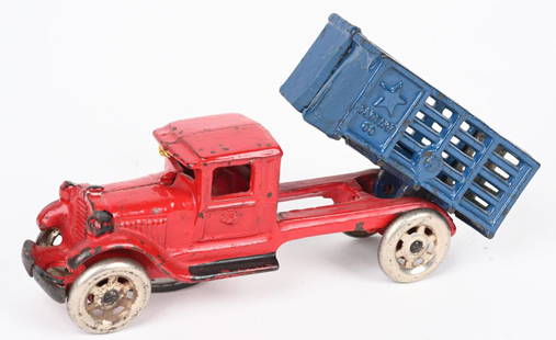 A.C. WILLIAMS CAST IRON STAR STAKE DUMP TRUCK: A.C. Williams cast iron Star Stake Dump Truck. Looks to be all original with red cab, blue stake bed and nickel plated gate. Has black on accents on cab that appear to original. No cracks or repairs.