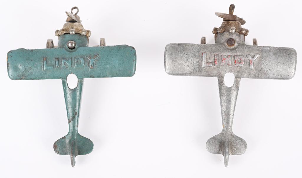 2- DENT CAST LINDY AIRPLANES: Lot includes a blue cast iron airplane, along with a silver cast aluminum airplane. 3 1/2" WS by 4". Very Good-Excellent
