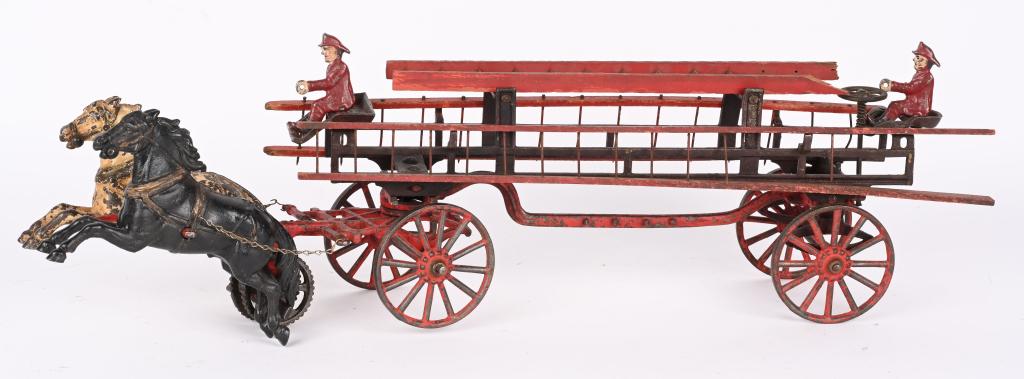 CARPENTER CAST IRON HORSE DRAWN FIRE WAGON: Original late 19th century Carpenter Fire Patrol Wagon. The toy features 2- 7" horses, 3 wood ladders, and 2- cast iron Firemen. Measures 26" overall and has no cracks or repairs. The Firemen are like