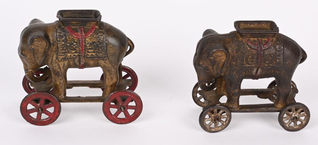 2- AC WILLIAMS CAST IRON ELEPHANT BANKS ON WHEELS: Nice pair of 2 different cast iron Elephant bank pull toys. No cracks or repairs. 4 1/2". Very Good-Excellent