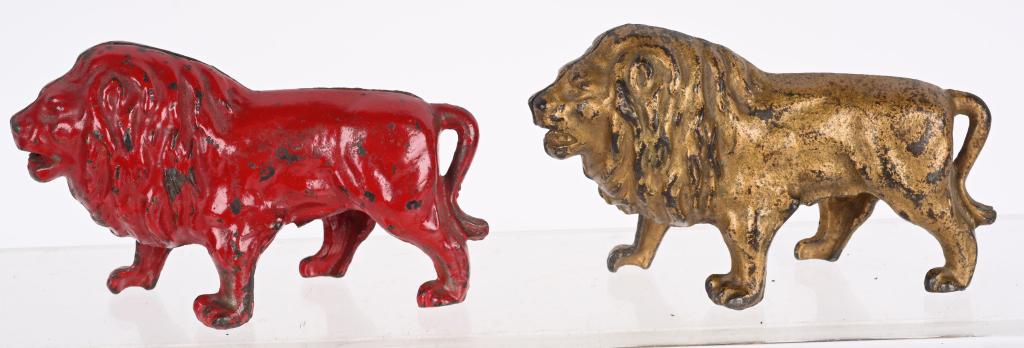 2- ARCADE LION WITH TAIL BETWEEN LEGS BANKS: 2 Arcade cast iron Lion with Tail Between Legs Still Banks. Scarce Red and Gold versions. Both all original with nice paint. 5 1/4" Excellent