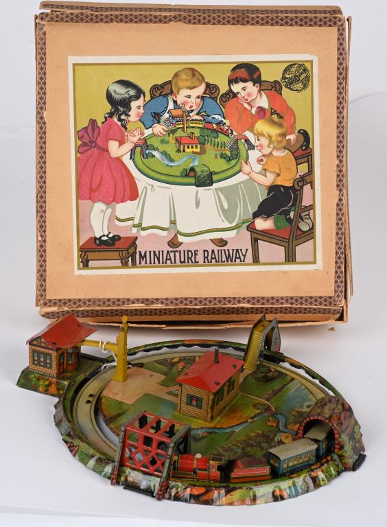 DISTLER TIN WINDUP MINIATURE RAILWAY w/ BOX: Very nice tin windup German Miniature Railway. All original with great colors and details. All complete with Train Station. Windup works. Comes with scarce Box 11" Excellent