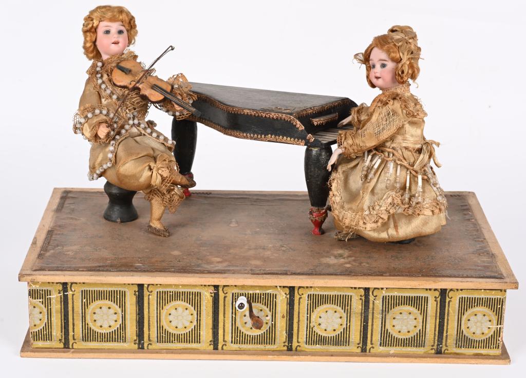 GERMAN HAND CRANK MUSICAL PIANO & VIOLIN AUTOMATON: German hand crank Musical Piano and Violin Automaton. Pair of bisque head figures that are well dressed and each playing their instruments. The toy is all original and in very nice condition. When you